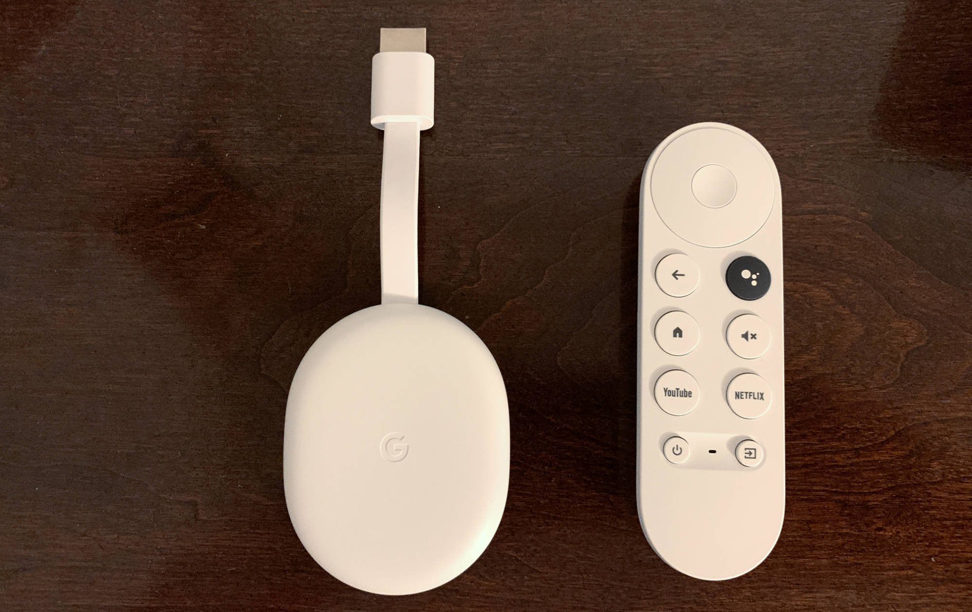 The Chromecast with Google TV is pictured alongside the Google Assistant voice remote.