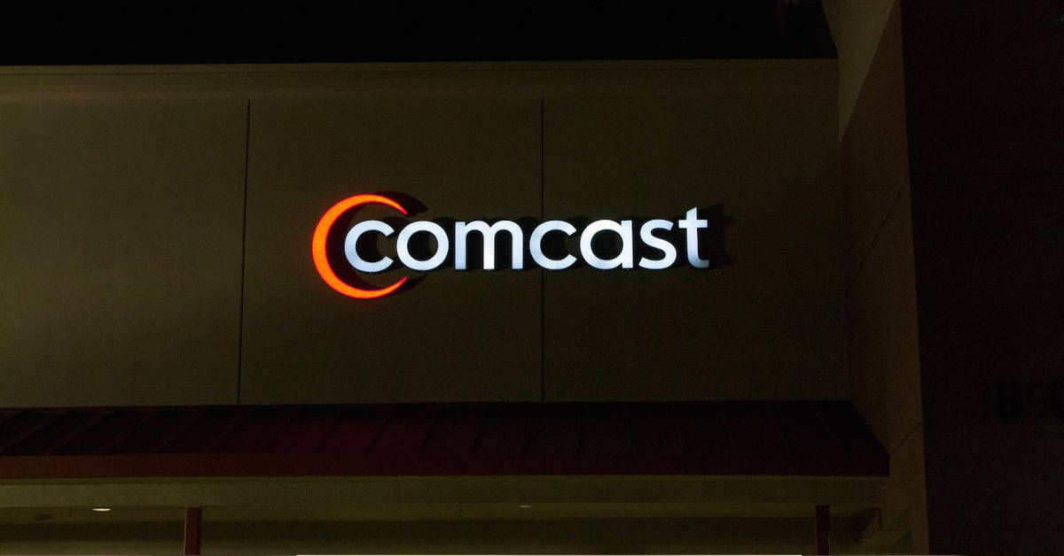 A picture of the Comcast logo on the front facade of a retail building.