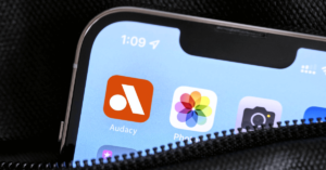 The Audacy streaming radio app appears on a smartphone. (Photo by Focal Foto, Creative Commons; Graphic by The Desk)