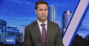 A news anchor for Spectrum News Plus during a broadcast in April 2023. (Still frame courtesy Charter Communications/Spectrum News, Graphic by The Desk)