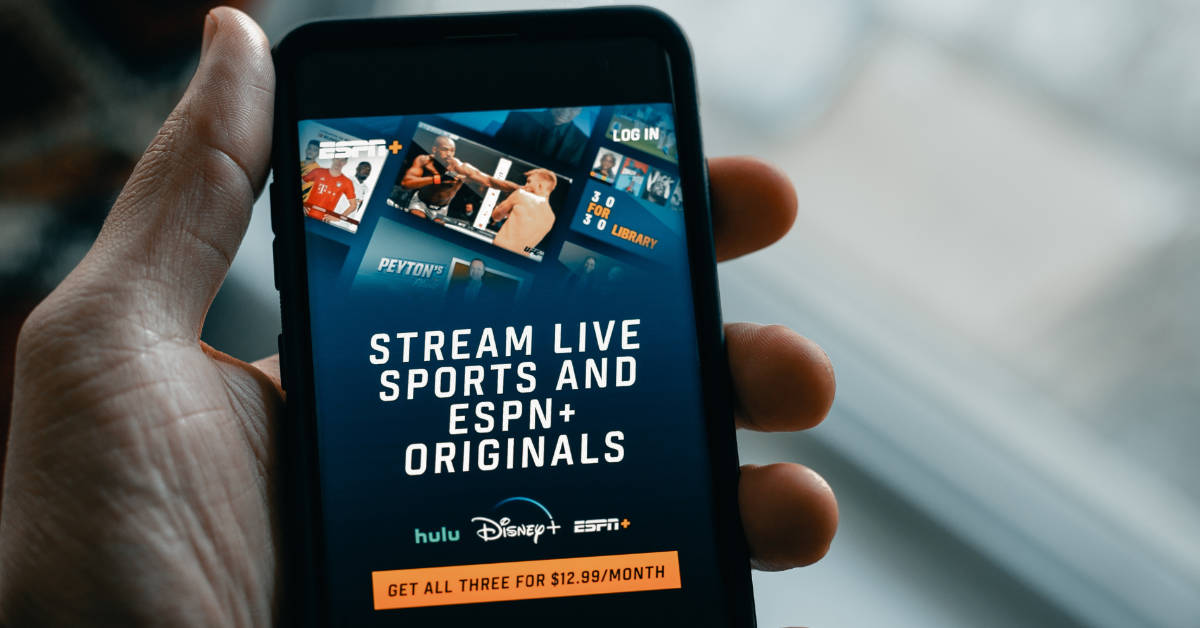 A person holding a phone with the ESPN Plus app.