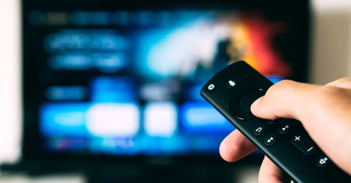 Stock image of remote control in front of a television set.