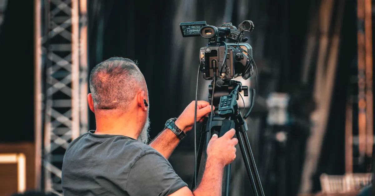 Stock image of man with professional video camera at a live event.